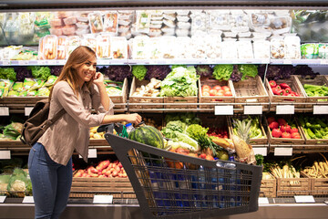 Woman and shopping cart in supermarket.