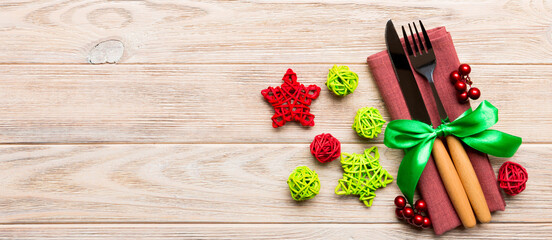 Top view Banner of holiday set of fork and knife on wooden background. Christmas decorations and toys with copy space. New Year Eve concept