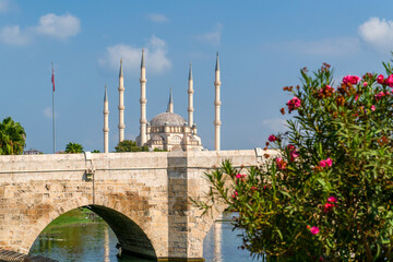 Sabanci Central Mosque with Seyhan River and flowers. Blue clean sky in background. Adana, Turkey.