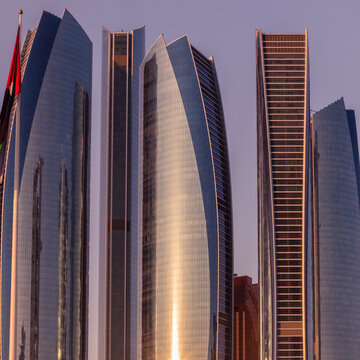 Abu Dhabi , UAE - 10 october 2020 : Capital City of United Arab Emirates with emirates flag, etihad towers, ADNOC head office,emirates palace and cityscape