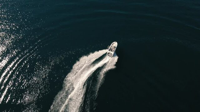Birds Eye View of Speed Boat Turns with White Water Spray