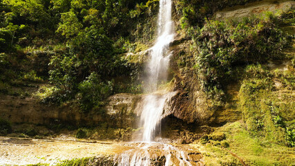 Fototapeta na wymiar Can-umantad Falls in green forest, aerial drone. Waterfall in the tropical mountain jungle. Bohol, Philippines.