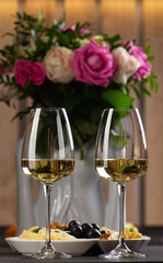 Two glasses of white wine are on the table.