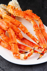 Crab legs in a plate on a dark background. Ready to eat.