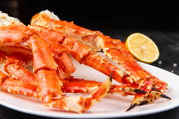 Crab legs in a plate on a dark background. Ready to eat.