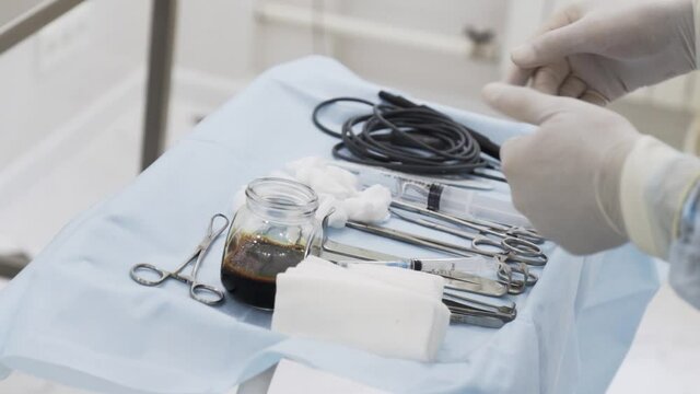 Close up of sterile surgical tools for laparoscopic surgery. Action. Tools for medical surgery with the glass bowl of iodine, concept of health and medicine.