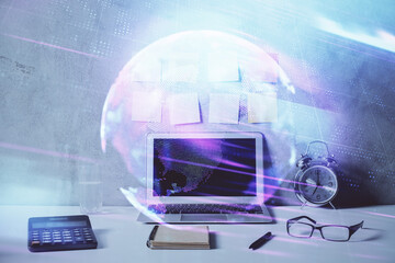 Computer on desktop in office with technology theme hologram. Double exposure. Tech concept.