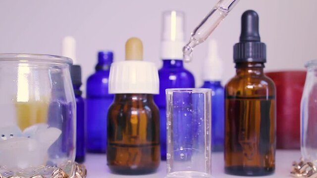 pipette dripping liquid into transparent container