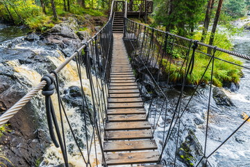 Fototapety  Most wiszący i kaskady wodospadów Achwenkoski na rzece Tochmajoki, popularnej atrakcji turystycznej położonej w pobliżu osady Ruskeala w Karelii w Rosji