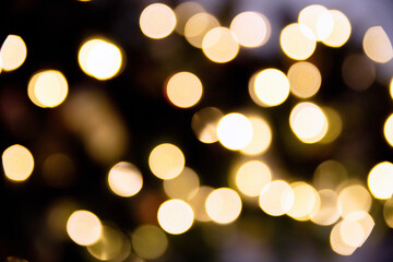 Fototapeta premium Christmas lights. Bokeh lights against a dark background. Christmas garlands with a blurred focus in the form of a Golden bokeh.