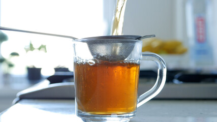 Image with Making a Hot and Aromatic Tea Using a Strainer and Natural Tea Leafs