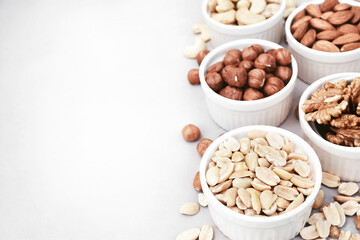 Colorful mix of various nuts: peanut and cashew, hazelnut and almond, pine nuts and  walnut; healthy diet snack; selective focus, shallow DOF