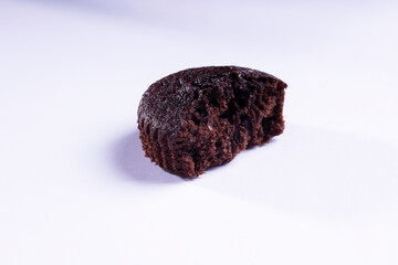 a half of plain dark chocolate cupcakes  on white background
