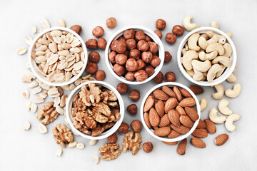 Colorful mix of various nuts: peanut and cashew, hazelnut and almond, pine nuts and  walnut; healthy diet snack; vegan food background