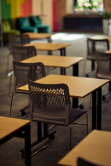 Vertical shot of empty classroom or conference room with desks and chairs, selective focus