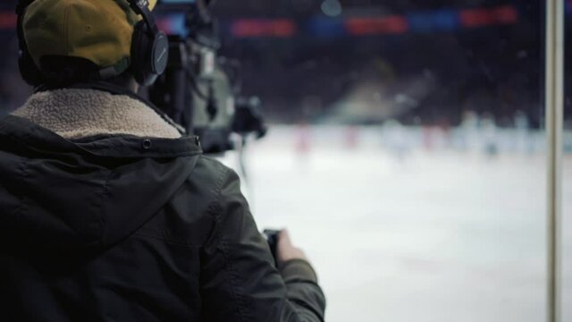 Cameraman shooting ice hockey game.