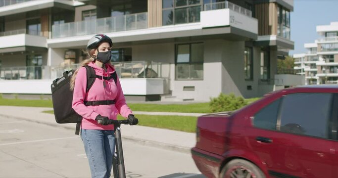 Fast food delivery courier rides electric scooter