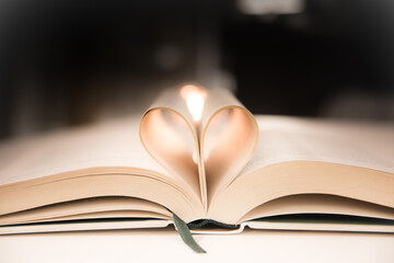 Heart from a book page against a dark background