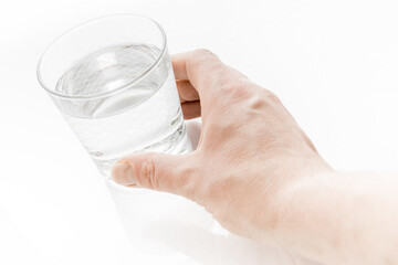 Man hand isolated holding a glass of water on bright white background.