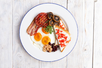 Fried eggs, toast mushrooms and beans in a plate.