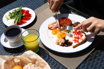 Breakfast outside. Fried eggs, coffee, croissants. Hands in the frame.