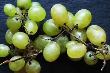 Photography of a bunch of italian seedless white grapes on slate for food background