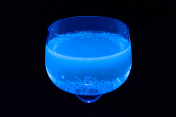 Glass of tonic glowing in UV