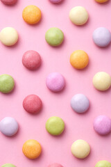 Colorful round candy sweets pattern on a pink background viewed from above. Top view