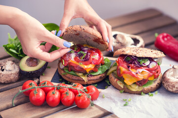 Food blog enthusiast assembling a Vegan or Vegetarian burger with patty from impossible meat as an...