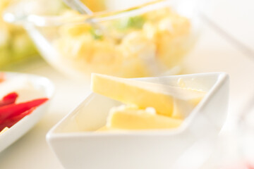 Breakfast table - butter, egg and mayo sandwich filling, sliced peppers
