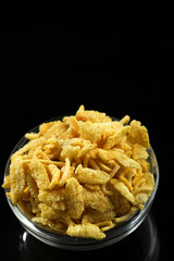 Indian snacks in bowl on dark background