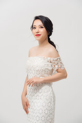 Attractive young Asian lady wearing white skinny dress isolated over white background.