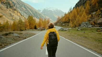 Camera follows woman on trip or adventure. Young millennial traveller or travel blogger walk in beautiful mountain valley and make photos for social media or memories. Generation z new concept travels