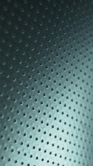 Dark metallic mobile wallpaper. Perforated aluminum surface with many holes. Tinted blue or green industrial background. Vertical metal backdrop. Macro