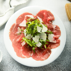 Traditional beef carpaccio with parmesan cheese and arugula
