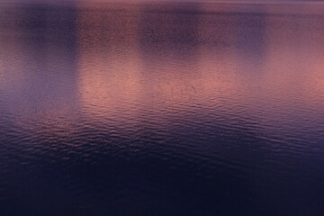 夕暮れを写した紫とオレンジの水面
