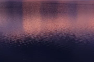 Fotobehang 夕暮れを写した紫とオレンジの水面 © MaP