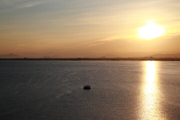 昇る朝日が湖に反射して綺麗な写真