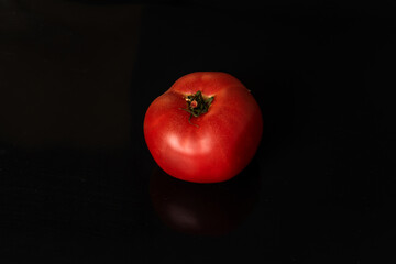 red tomato on black background