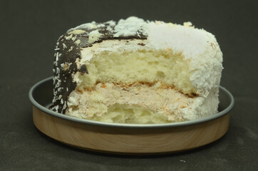 A bitten-off cake on a metal stand .