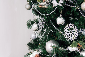 New Year's Space for text. Christmas green tree decorated with white and silver balls and toys