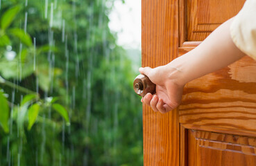 Women hand open door knob or opening the door raining day, grand opening, Close up hand open door.