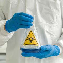 Erlenmeyer Flask contains blue liquid chemicals in experts hands.