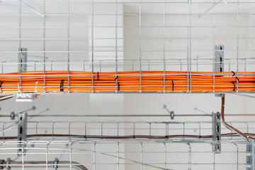 Electrical conduits system and metal pipeline installed on building ceiling, orange wires