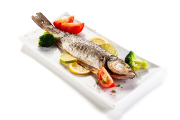 Fish dish - roasted trout with vegetables on white background
