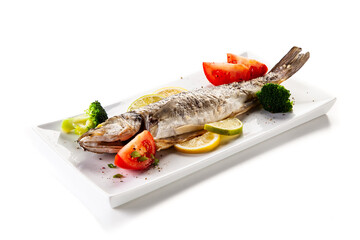 Fish dish - roasted trout with vegetables on white background
