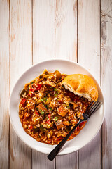 Roast pork meat with rice and vegetables on wooden background