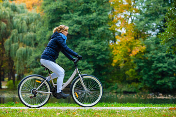 Obraz premium Urban biking - woman riding bicycle in city park 