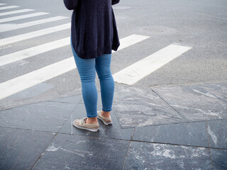Women's feet in front of a pedestrian crossing, start something
