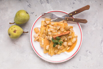 Thin pancakes (crepes) with apple filling, stuffed rolls, Russian traditional food for maslenitsa, French dessert, breakfast with tulips on mother's day